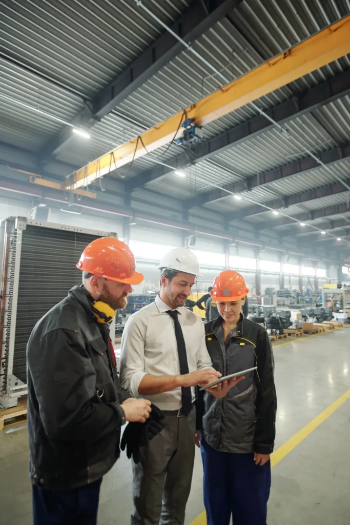 Profesionales con casco conversando en planta